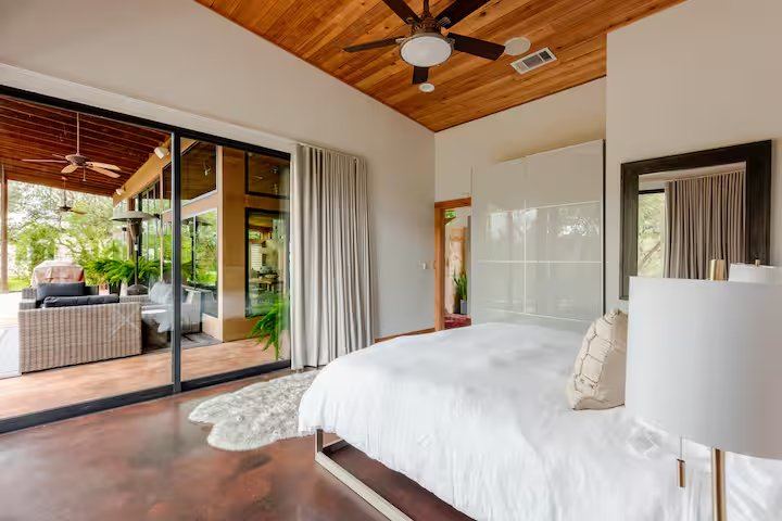 La Paz primary bedroom with sliding glass doors opening onto the covered patio