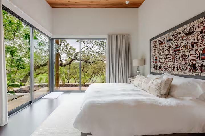 La Paz primary bedroom with woven tapestry headboard and silver lamps