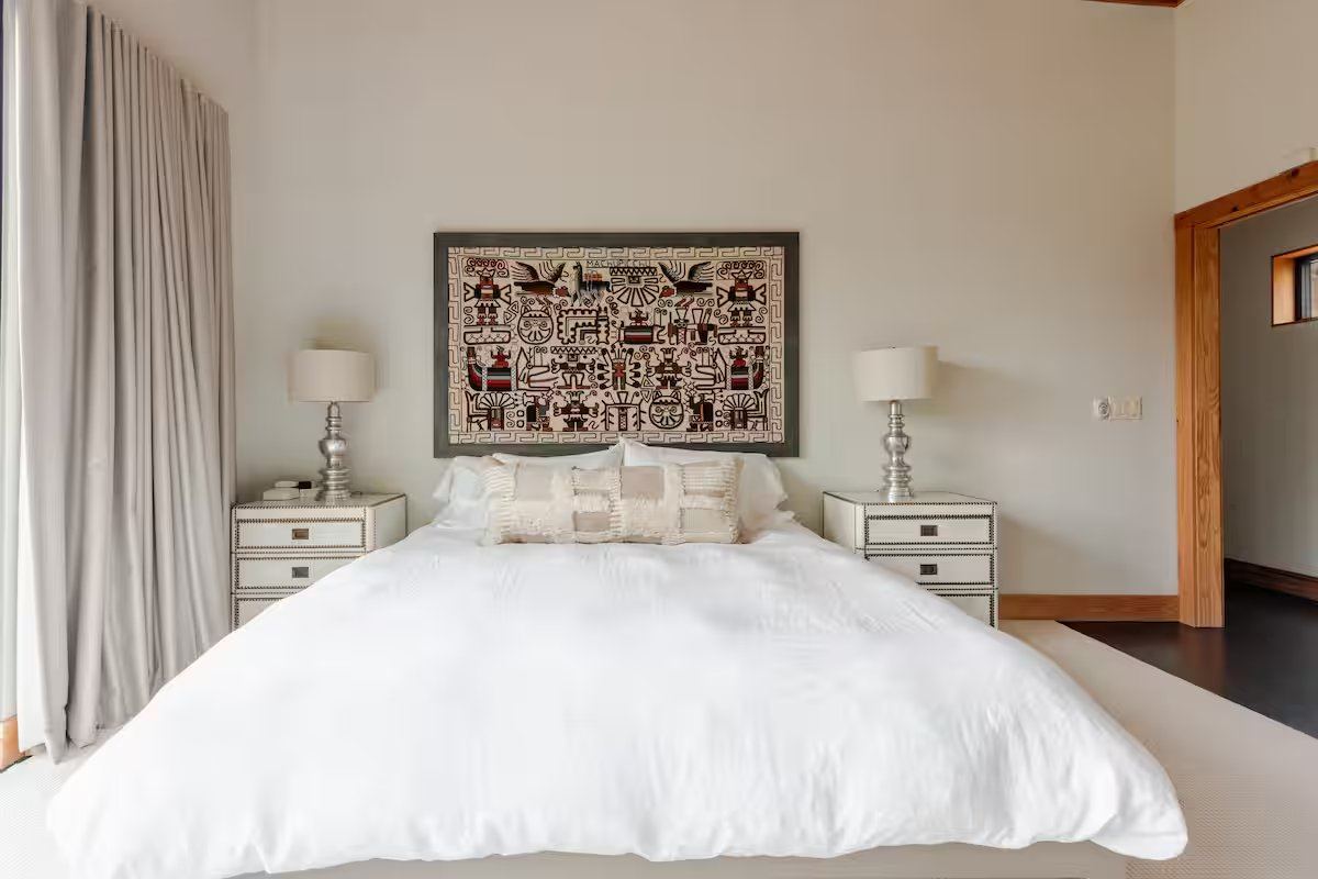 La Paz second bedroom with floor-to-ceiling windows overlooking live oaks