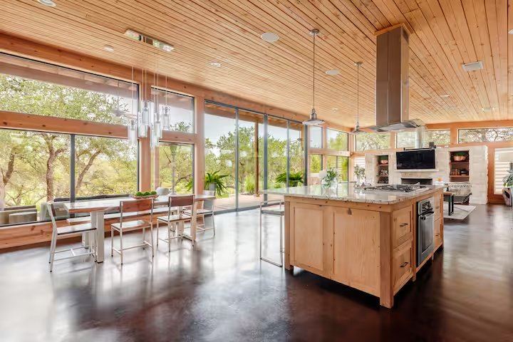 La Paz open kitchen with wood-cabinet island, pendant lights, and dining nook overlooking the oaks